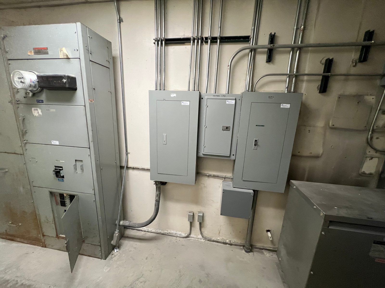 Commercial electrical room with a service switchgear section, two distribution panels and a transformer, tied together with EMT